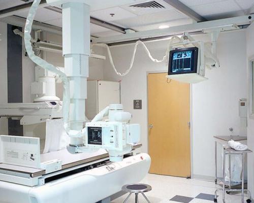 Interior photo of imaging room at Healthpark Hospital. X-ray table and monitoring equipment.